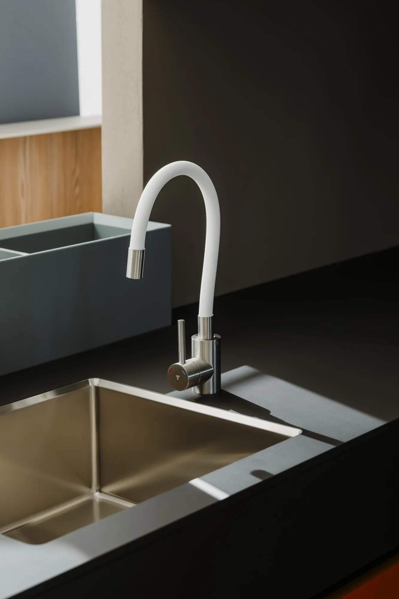 Tubico Gold PVD kitchen sink mixer over a stainless steel undermount sink