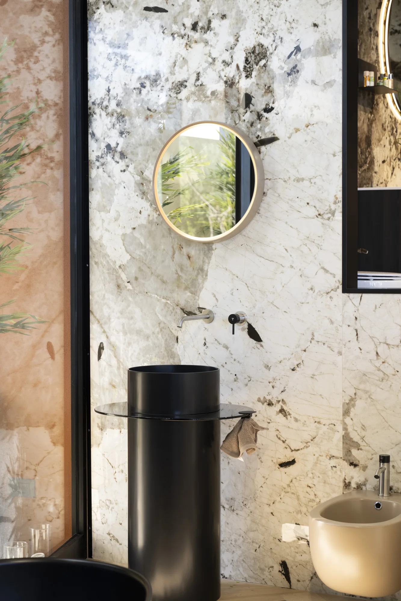 Tubico Gold PVD stainless steel basin mixer with a black stone basin against a marble wall