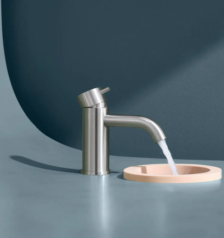 Fontea brushed steel tap over a pale pink basin against a blue wall