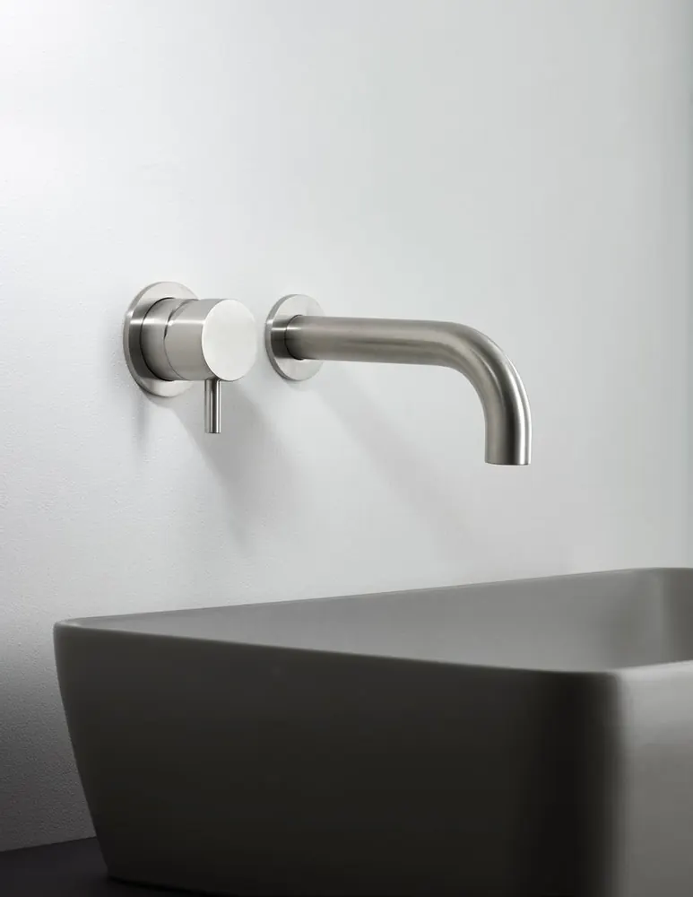 Fontea wall-mounted brushed steel tap over a grey washbasin