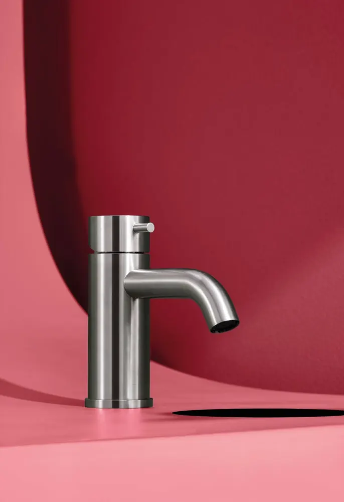 Fontea brushed steel tap against a deep red backdrop